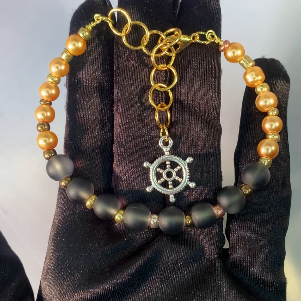 ECLIPSE HARBOR — Handmade Gold and Black Glass Beaded Bracelet with Wheel Charm